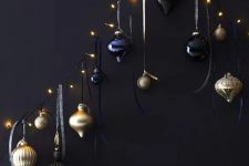 a unique Christmas tree of lights and black, navy and gold ornaments hanging on them is a lovely space-saving idea
