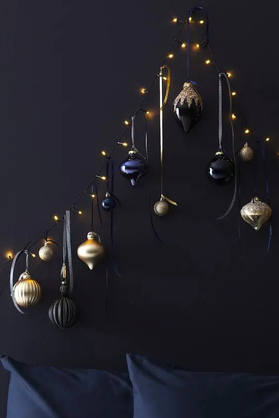 a unique Christmas tree of lights and black, navy and gold ornaments hanging on them is a lovely space saving idea