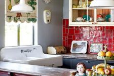 a vibrant maximalist kitchen with black and white cabinets, a red tile backsplash, a fuchsia kitchen island, a printed shade and vintage pendant lamps