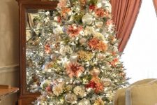 a vintage flocked Christmas tree with white and pastel blooms, mercury glass and silver ornaments is a chic and stylish idea