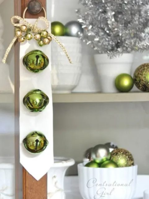a white tie with green bells and mini ornaments plus a bow can be hung on doors of all kinds to bring a holiday feel to them