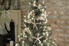 a white vintage urn with a Christmas tree, lights, seashells and starfish is a cool idea for a beach Christmas space