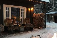 a winter terrace with a wooden chairs covered with faux fur, candle lanterns, a stack of firewood, a fire bowl is awesome