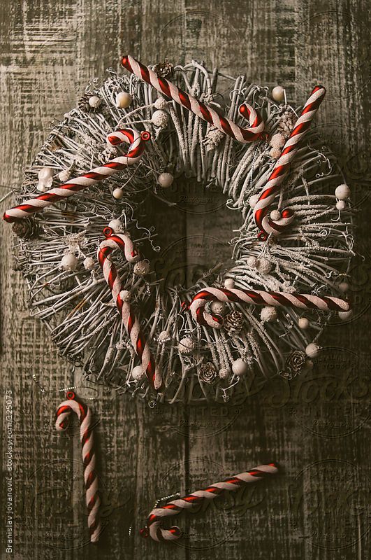 a wire Christmas wreath with white beads and snowy pinecones plus candy canes is a lovely and creative wreath idea for Christmas