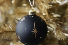 an elegant black and gold Christmas ornament with rhinestones and stars is a cool decoration for the holidays