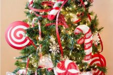 bright Christmas tree decor with red ribbons and oversized red and white fabric peppermints and candy canes looks fun and bold