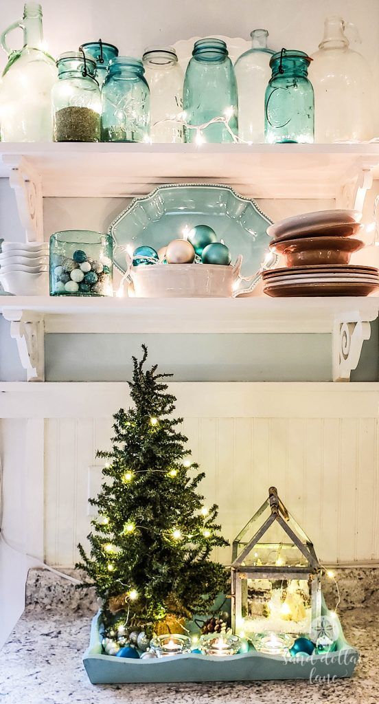 coastal Christmas decor with aqua and blue decor   jars, ornaments, a tray with a small Christmas tree and baubles