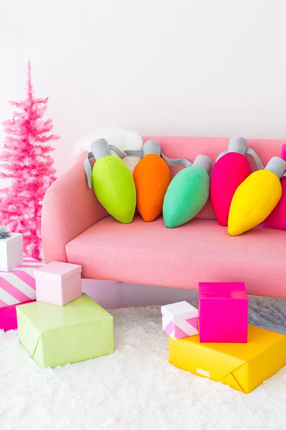 colorful vintage lights pillows, bold Christmas gift boxes and a hot pink Christmas tree will make your space ultimate
