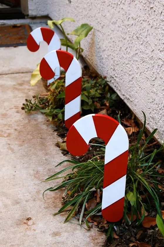cool outdoor holiday decor   growing greenery accented with candy canes looks very bright and very cool