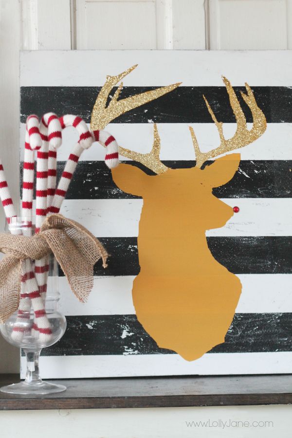 crochet candy canes in a jar and a striped sign plus a deer silhouette make up a lovely Christmas decoration