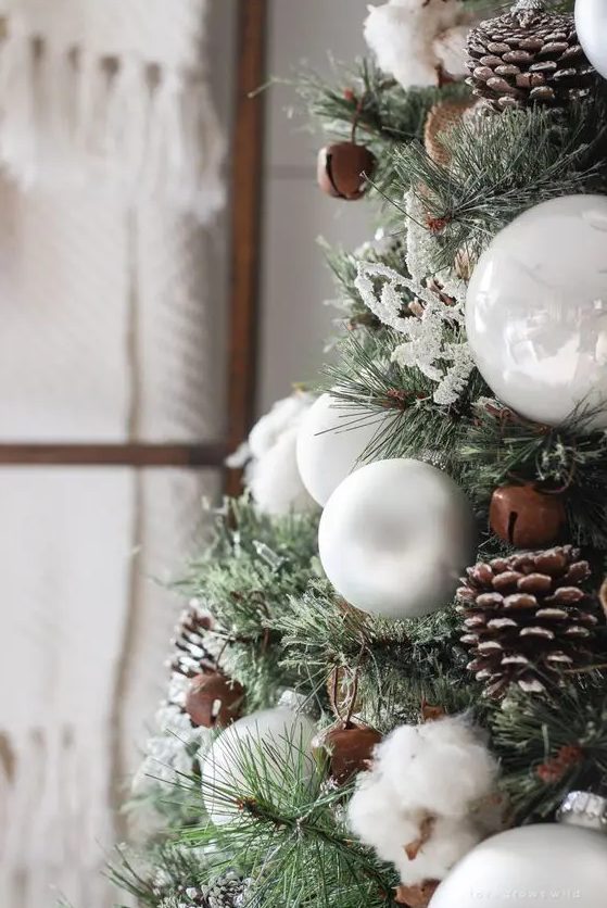 decorate your Christmas tree with pinecones, cotton, bells and white ornaments to give it a cozy rustic look
