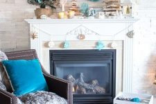 fabulous coastal Christmas decor with a fun coastal-themed garland, a turquoise wreath with shells, a mni tree, driftwood trees and candles