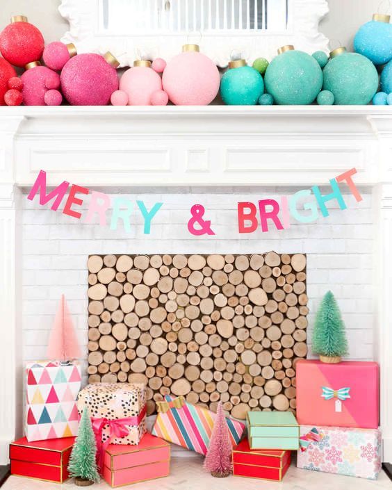 fabulous colorful holiday decor with an ombre Christmas ornament mantel, a matching letter banner, colorful gift boxes and mini trees