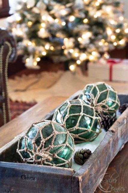 lovely coastal Christmas decor with a shabby chic tray, pinecones, green buoys in net is a cool centerpiece or just decoration to rock