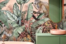 tropical maximalist bathroom with jaw-dropping wallpaper, a pink bathtub and sink, a green vanity and an oval mirror just wows