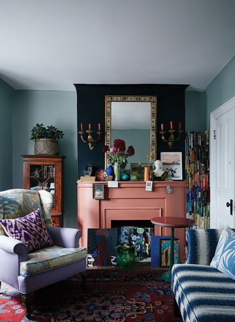 a bright whimsical living room with a salmon pink fireplace and colorful artworks looks unusual