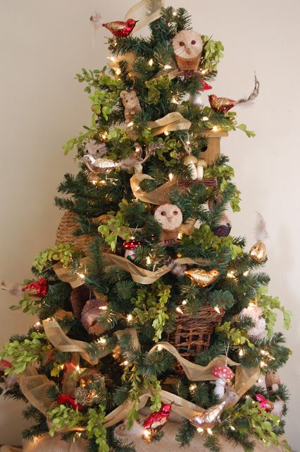 a bright woodland Christmas tree with mushrooms, owls, little forest animals, lights, greenery, neutral ribbons is cool
