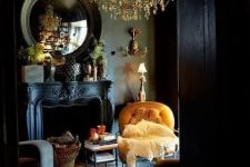 04 a black painted vintage fireplace with firewood in a basket adds an exquisite feel to this gorgeous moody living room with a statement chandelier