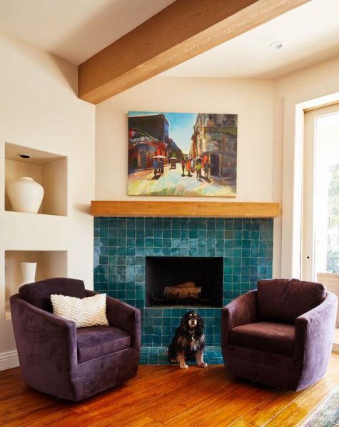 a chic and cozy nook with a fireplace clad with Zellige teal tiles and purple chairs for enjoying warmth