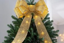 04 a gorgeous pre-lit gold glitter oversized bow is a fantastic glam Christmas tree topper for many styles