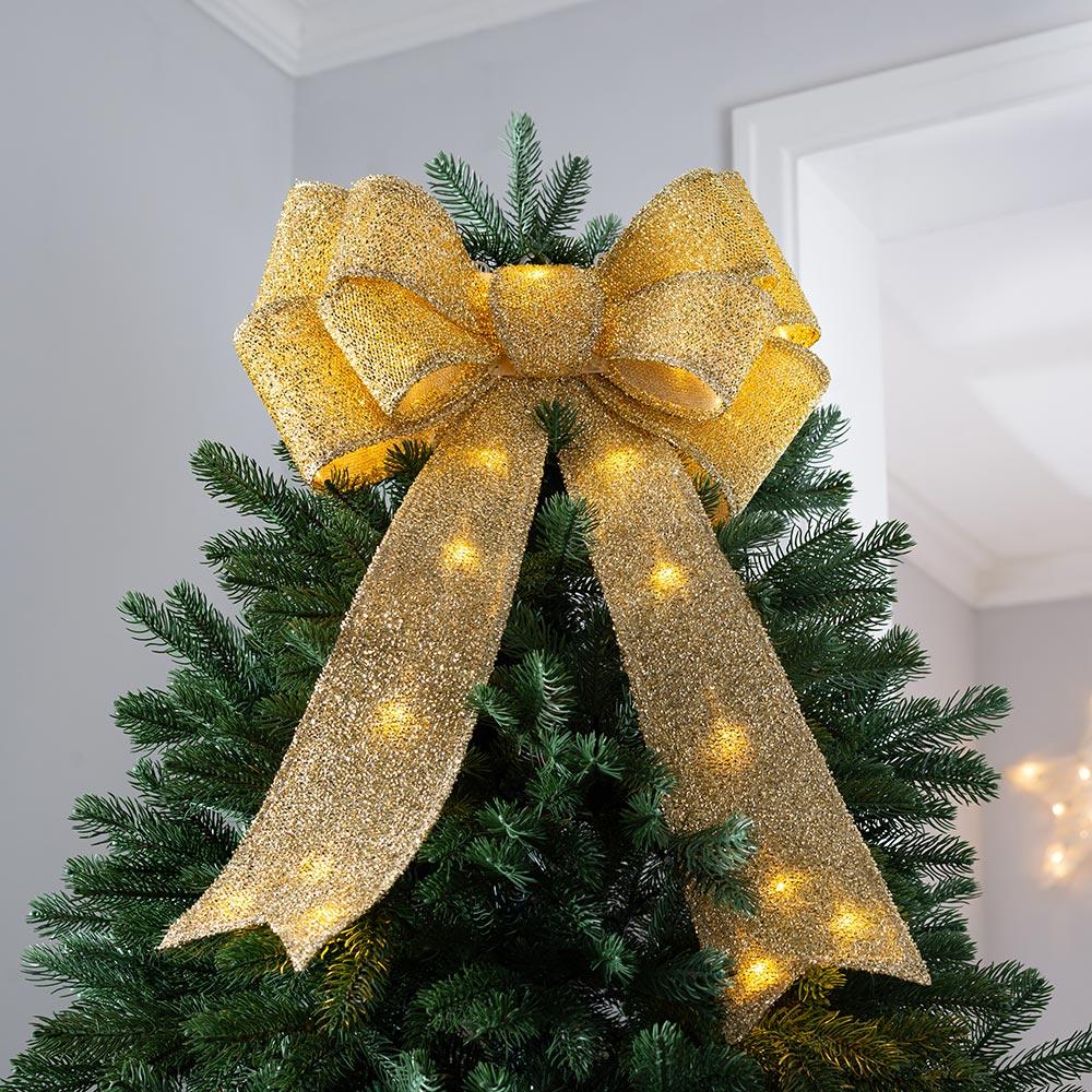 A gorgeous pre lit gold glitter oversized bow is a fantastic glam Christmas tree topper for many styles