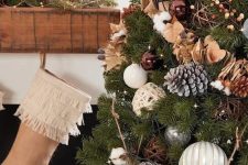 05 a Christmas tree with lights, brown, silver and white ornaments, wooden beads, snowy pinecones, cotton and bells is a great idea for both a rustic or a forest celebration
