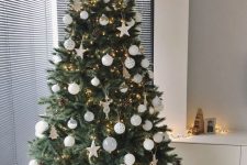 05 a chic neutral Christmas tree with white and white spotted ornaments, stars and mini Christmas trees, lights and pinecones is amazing for a modern space