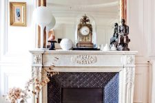 05 a fabulous vintage fireplace with an ornated white mantel, an oversized mirror and some vintage decor on the mantel