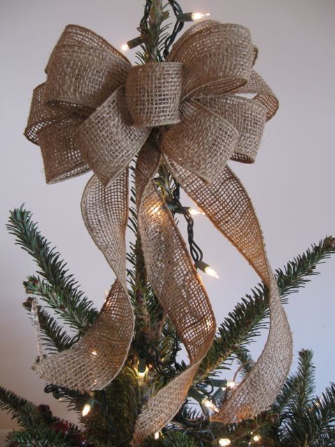 a large burlap bow is a great Christmas tree topper with a strong rustic or woodland feel, and you can DIY it easily