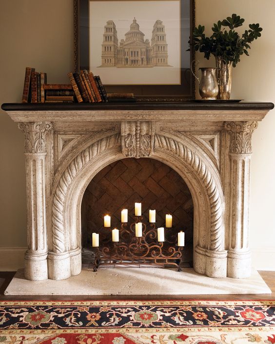 a gorgeous arched fireplace with a beautiful rope ornated mantel and a candelabra inside is amazing