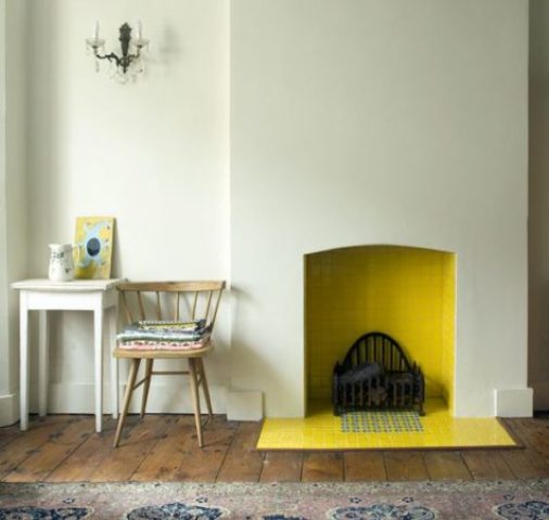 a minimalist non working fireplace with yellow tiles inside and out that brings a warm feeling to the space