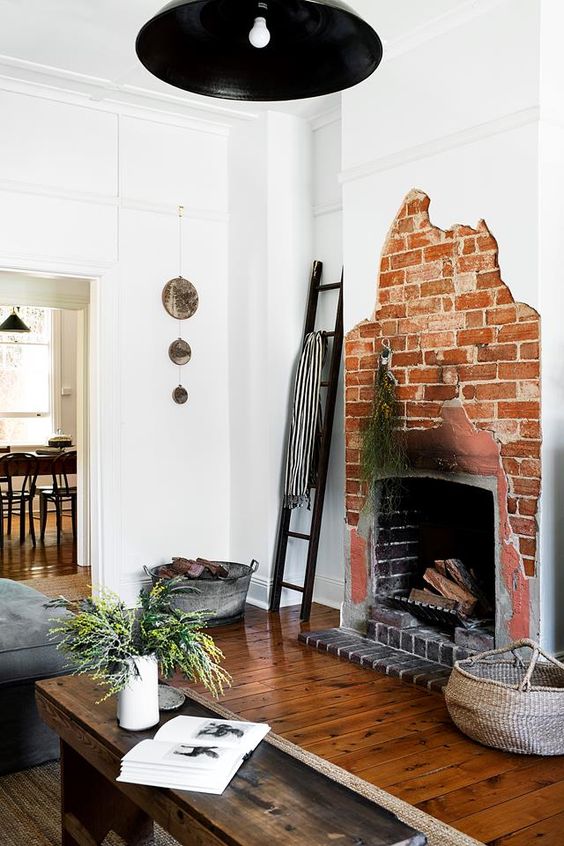 a creative asymmetrical red brick fireplace is a unique feature to go for, it's a bold solution that looks rough and unusual