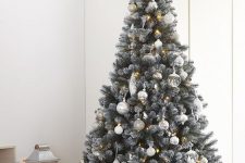 09 a delicate neutral Christmas tree decorated with white, silver and semi sheer ornaments, lights and a lit up star tree topper