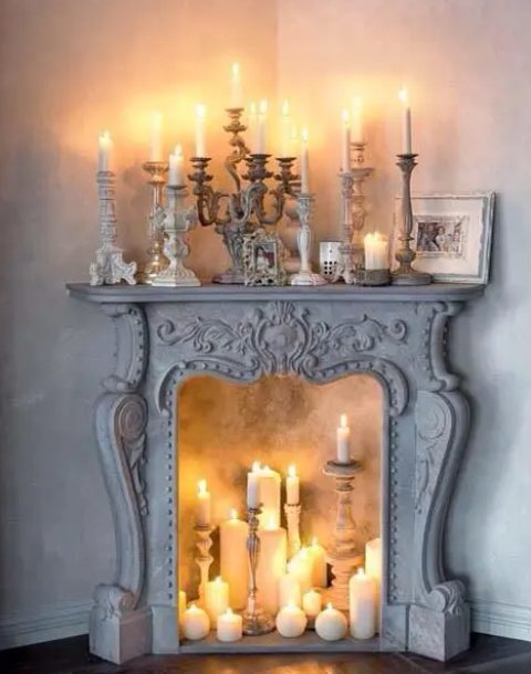 a whitewashed vintage fireplace with lots of candles inside and on the mantel looks fantastic, chic and beautiful and makes the space wow
