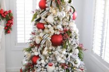 10 an extra bold Christmas tree decorated with oversized white, red and green ornaments, berries, ribbons and a marquee star topper