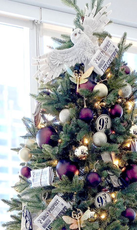 a bright Harry Potter christmas tree topped with an owl bringing a newspaper is a gorgeous and chic idea for a geeky space
