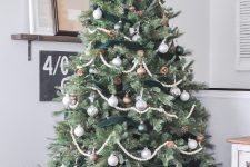 12 a fantastic farmhouse Christmas tree with wooden bead and green velvet garlands, silver, brown and white ornaments and pinecones is amazing