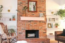 12 a modern living room with a red brick fireplace, niche shelves, a printed rug, stained and upholstered furniture and potted plants