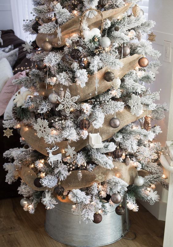 a refined woodland Christmas tree in white, with brown, copper, silver and white ornaments, deer silhouettes, snowflakes and berries is amazing