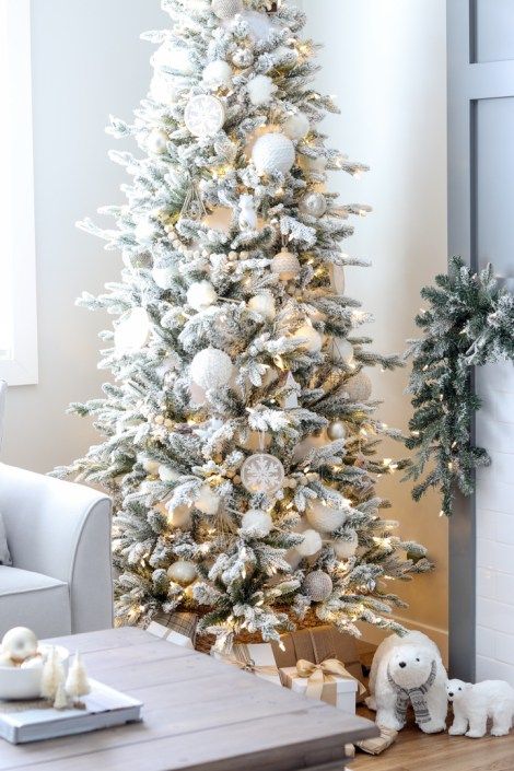 a flocked Christmas tree with lights, oversized snowball ornaments, embroidered snowflake ones and wooden beads is a beautiful idea