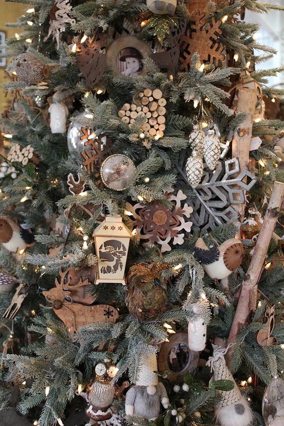 a rustic woodland Christmas tree with plywood snowflakes, deer silhouettes, owls, pinecones, photos, mini birds and berries plus mesh ribbons
