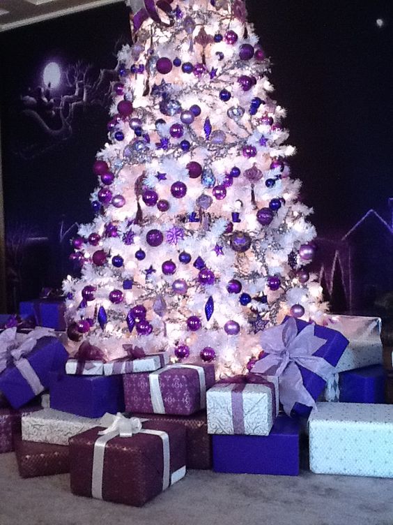 a white Christmas tree with deep purple, lilac and bold purple ornaments of various shapes that looks amazing