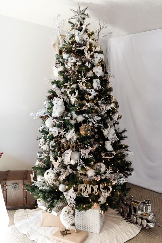 a woodland Christmas tree with faux owls, deer, snowflakes, silver, white and pearly ornaments, branches, lights and letters