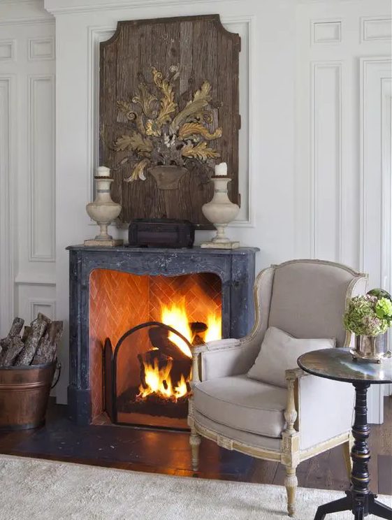 a brick fireplace with a black stone mantel and a metal cover gives a beautiful and chic touch to the space making it wow