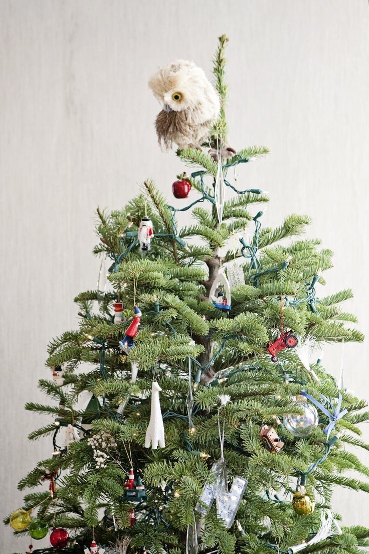 a creative Christmas tree with fun elf figurines, letters, sheer ornaments, apples and other stuff plus a creative owl tree topper