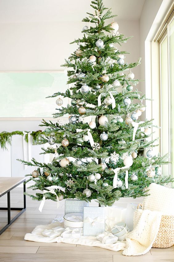 a luxurious neutral Christmas tree with silver, gold, white and light green ornaments, white ribbon bows, lights, snowflakes is wow