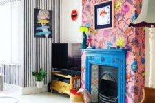 18 a blue fireplace mantel, colorful tiles and pink floral wallpaper around that accent the hearth even more
