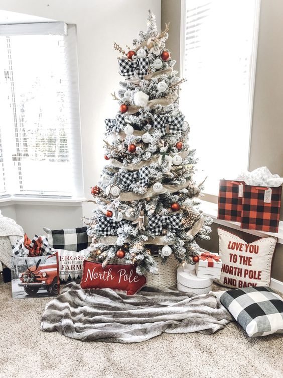 a farmhouse Christmas tree with mesh and buffalo check ribbons, white and red ornaments, branches and elegant pillows