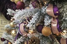 19 a flocked Christmas tree with purple and gold glitter ornaments, gilded pinecones, lights and copper disco balls