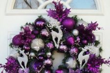 20 a bright and shiny Christmas wreath made with purple and silver ornaments, purple blooms, beads and silver deer plus a large bow